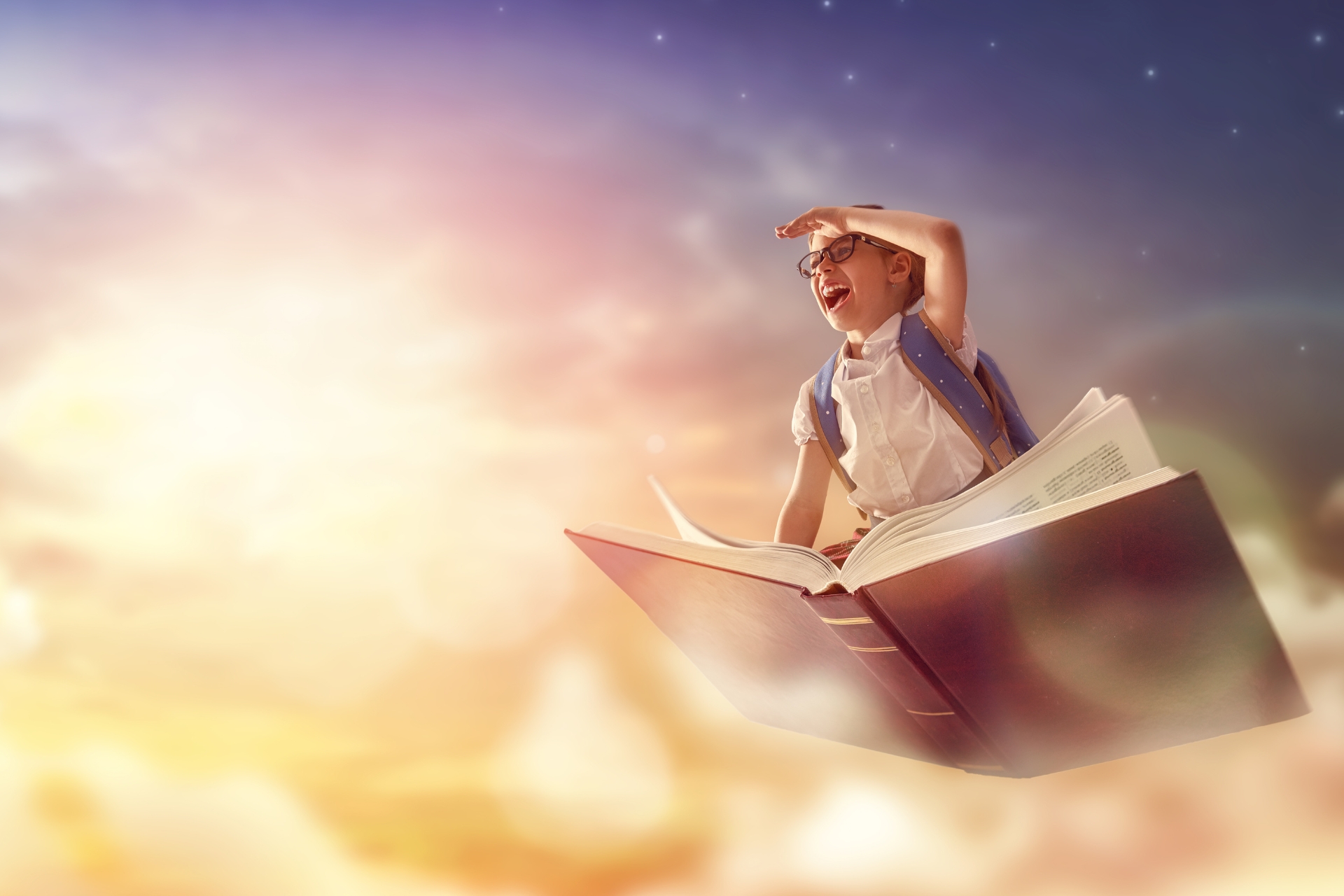 Fantasibild med pojke som flyger med en bok.